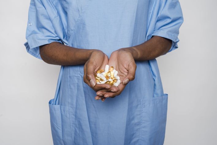 Unrecognizable black female patient with medical pills
