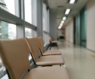 Row of empty chairs in a hospital corridor, soft lighting and modern interior design.